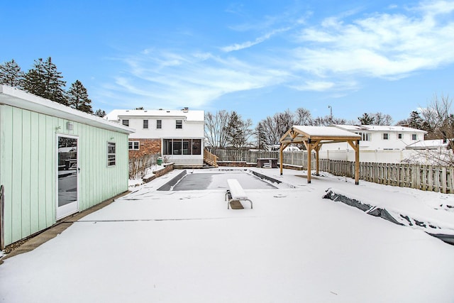 yard covered in snow featuring a gazebo and a sunroom