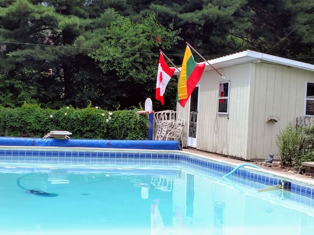 view of pool featuring an outbuilding