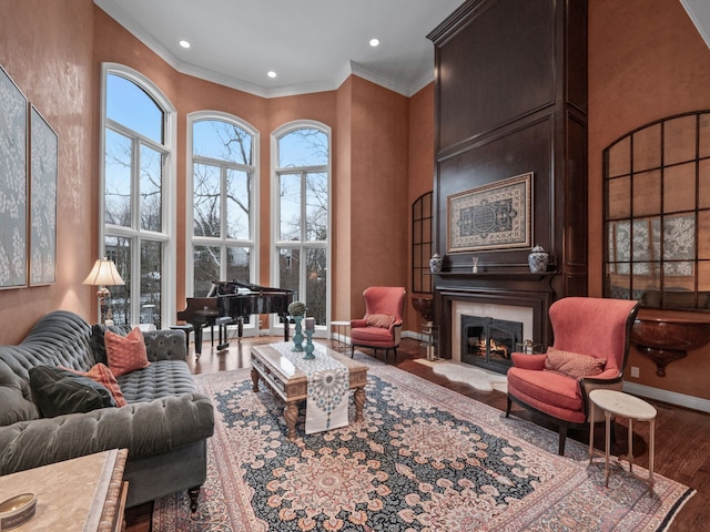 living room featuring hardwood / wood-style floors, crown molding, and a high ceiling