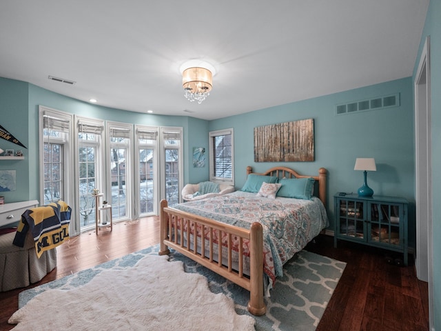 bedroom featuring dark hardwood / wood-style flooring and an inviting chandelier