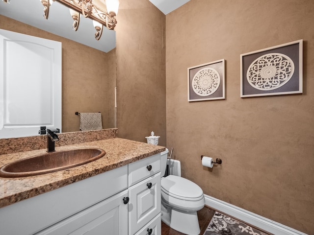 bathroom with hardwood / wood-style flooring, vanity, and toilet