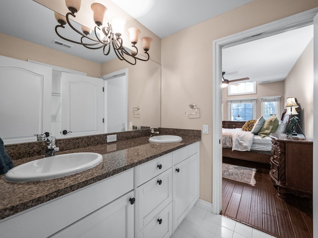 bathroom featuring vanity, ceiling fan with notable chandelier, and tile patterned flooring