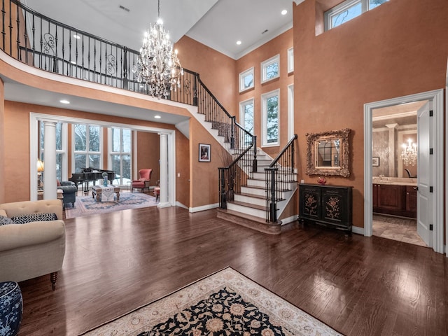 entryway featuring wood-type flooring, a high ceiling, and a notable chandelier