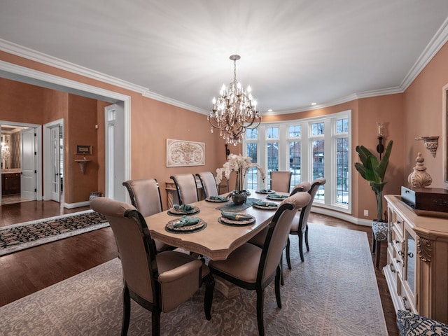 dining area with dark hardwood / wood-style flooring, an inviting chandelier, and crown molding