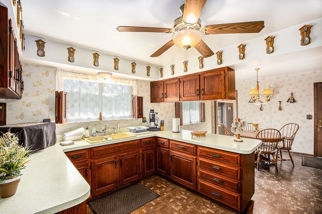 kitchen featuring sink, decorative light fixtures, kitchen peninsula, and ceiling fan