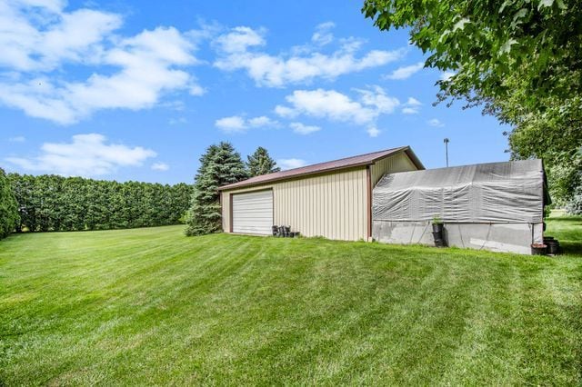 view of yard featuring a garage and an outbuilding