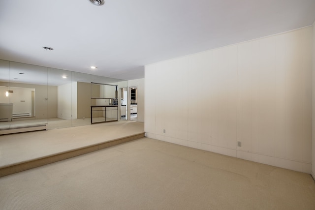 basement featuring carpet floors and a baseboard heating unit