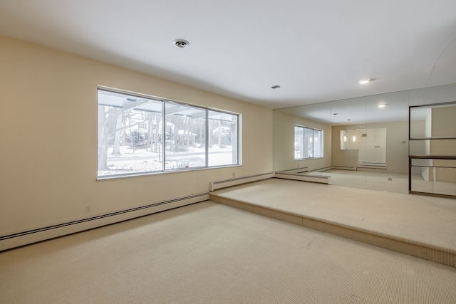 empty room with light colored carpet and a baseboard heating unit