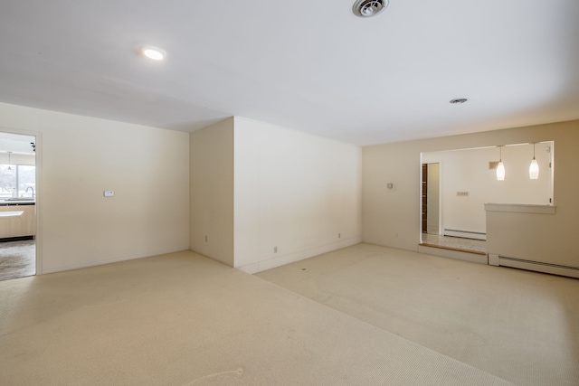 spare room with light colored carpet and baseboard heating