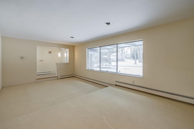 spare room with carpet floors and a baseboard heating unit