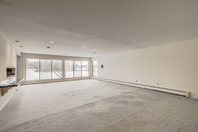 unfurnished living room with light colored carpet and a baseboard radiator