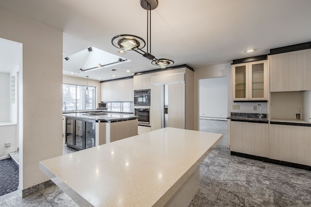 kitchen with a skylight, a center island, sink, paneled built in refrigerator, and pendant lighting