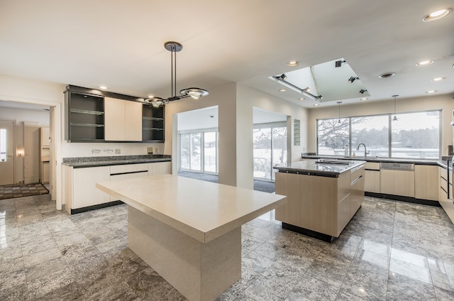 kitchen with a large island, sink, dishwasher, hanging light fixtures, and a notable chandelier