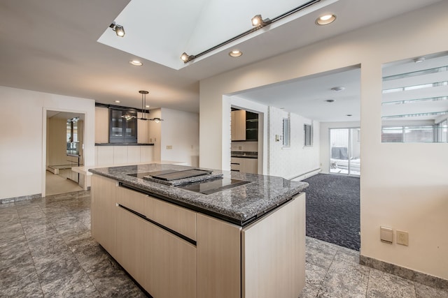 kitchen with hanging light fixtures, carpet floors, black electric cooktop, light brown cabinetry, and a kitchen island