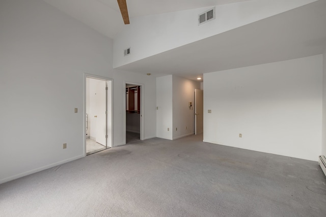 empty room with beamed ceiling, light colored carpet, and high vaulted ceiling