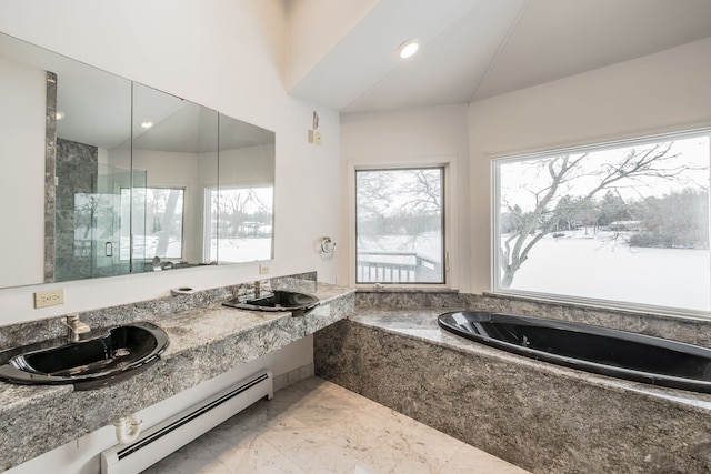 bathroom featuring a baseboard radiator, a relaxing tiled tub, and sink