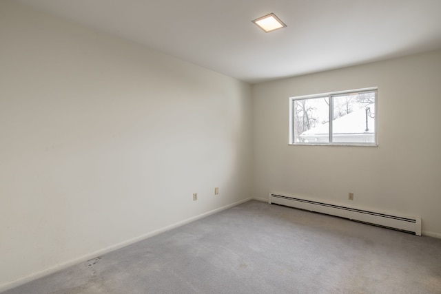 carpeted spare room with a baseboard heating unit