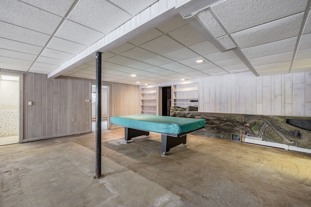 recreation room with wooden walls, a drop ceiling, billiards, and concrete floors