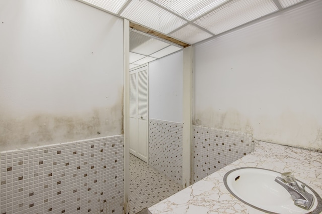 bathroom featuring vanity and tile walls