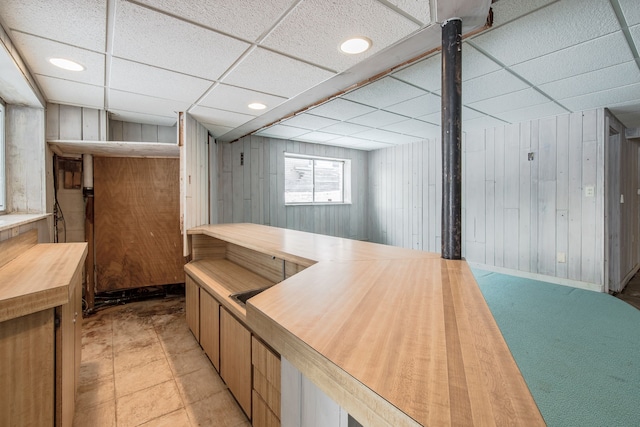 bar featuring wood walls and a drop ceiling