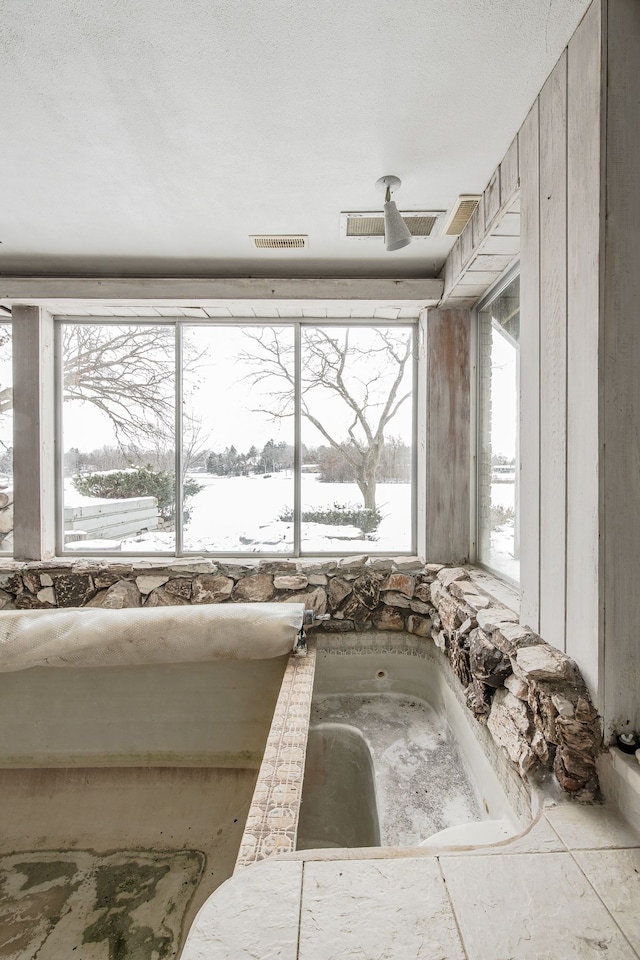 bathroom with a wealth of natural light and a textured ceiling