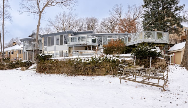 snow covered house with a sunroom