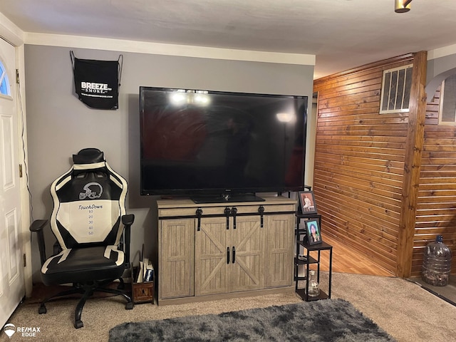 carpeted living room with wooden walls