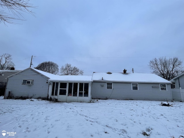 snow covered house with a sunroom