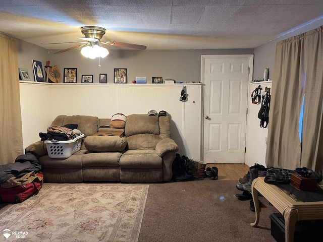 living room featuring carpet flooring, ceiling fan, and a textured ceiling