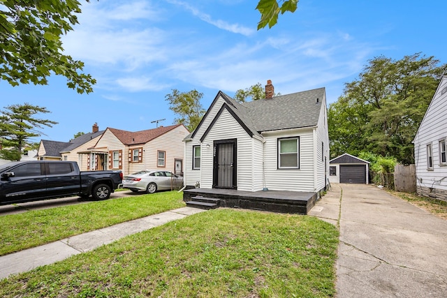 bungalow with an outbuilding, a front lawn, and a garage