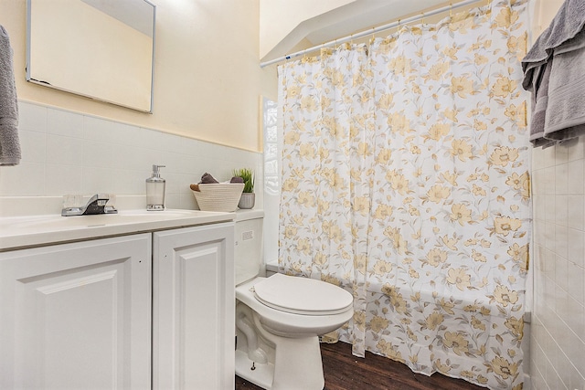 bathroom with walk in shower, vanity, wood-type flooring, tile walls, and toilet