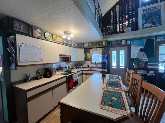 kitchen featuring electric range oven, sink, white cabinetry, a textured ceiling, and light tile patterned flooring