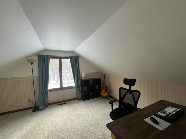 carpeted home office featuring lofted ceiling