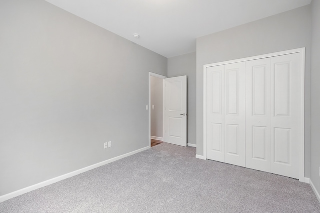 unfurnished bedroom featuring carpet floors and a closet