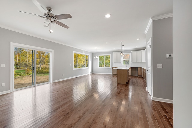 unfurnished living room with ceiling fan, wood-type flooring, and ornamental molding