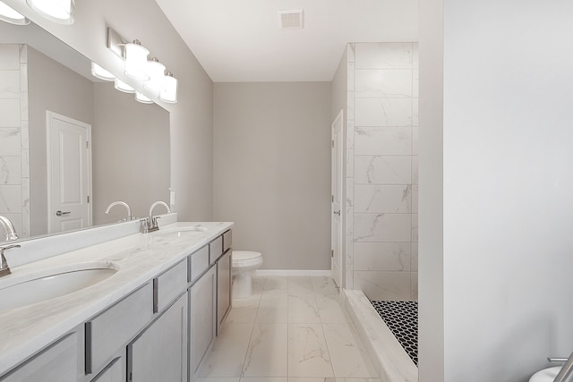 bathroom featuring vanity, toilet, and tiled shower