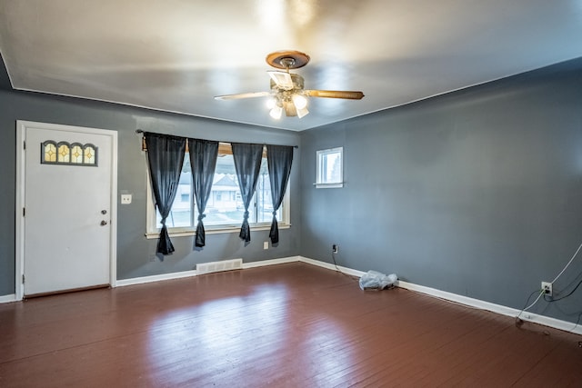 empty room with dark hardwood / wood-style flooring and ceiling fan