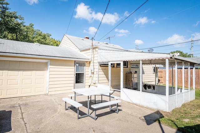 rear view of property with a sunroom and a patio