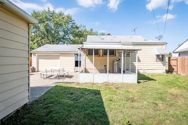 back of property featuring a sunroom, a yard, and a garage