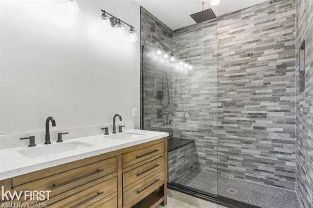 bathroom featuring a tile shower and vanity