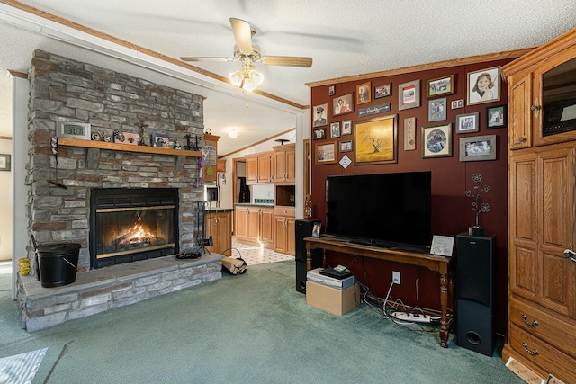 carpeted living room featuring a textured ceiling, ceiling fan, crown molding, a fireplace, and lofted ceiling