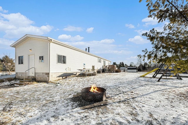 snow covered house featuring a fire pit