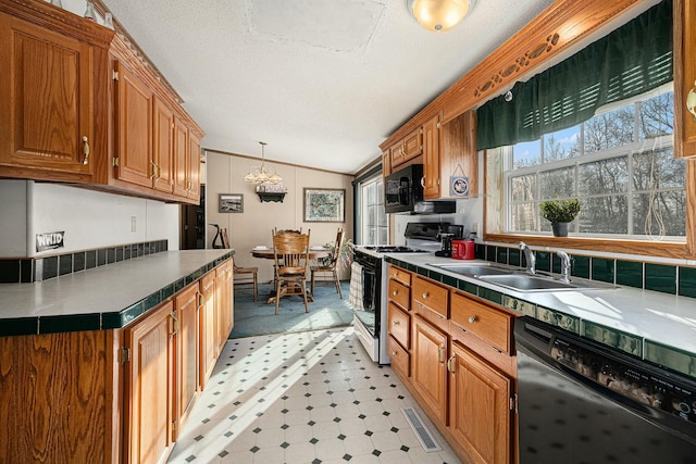 kitchen featuring dishwasher, lofted ceiling, sink, decorative light fixtures, and white range with gas cooktop