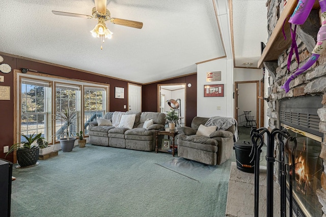 living room with carpet flooring, a stone fireplace, ceiling fan, and vaulted ceiling