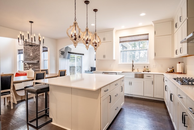 kitchen with plenty of natural light, a center island, dark wood-type flooring, and decorative light fixtures