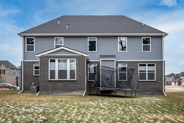 rear view of property featuring a trampoline and central AC unit