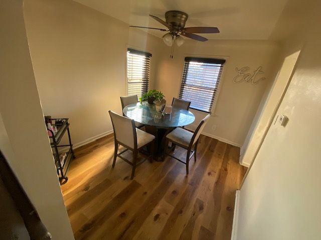 dining area featuring ceiling fan and dark wood-type flooring