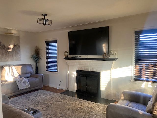 living room featuring a fireplace and dark wood-type flooring