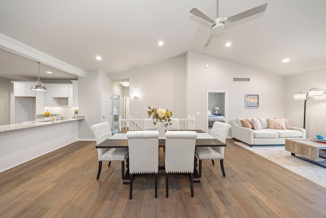 dining space featuring ceiling fan, dark wood-type flooring, and vaulted ceiling