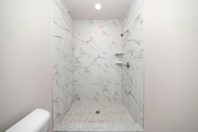 bathroom featuring toilet and tiled shower